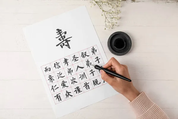 Asiatischer Kalligraph Schreibt Hieroglyphen Auf Weißem Hintergrund — Stockfoto
