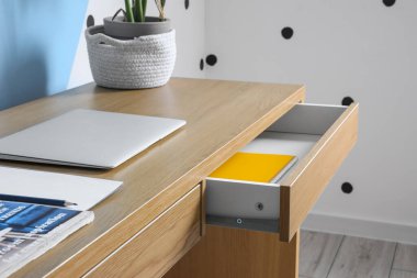 Ahşap masadaki modern dizüstü bilgisayar, açık çekmece, yakın çekim