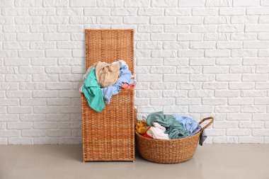 Beyaz tuğla duvarın yanında çamaşır sepetleri