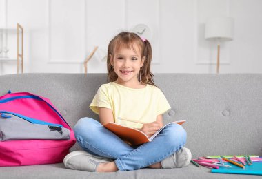 Küçük kız evde dersini alıyor.