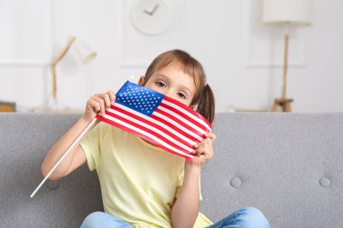 Evde Amerikan bayrağı taşıyan küçük bir kız