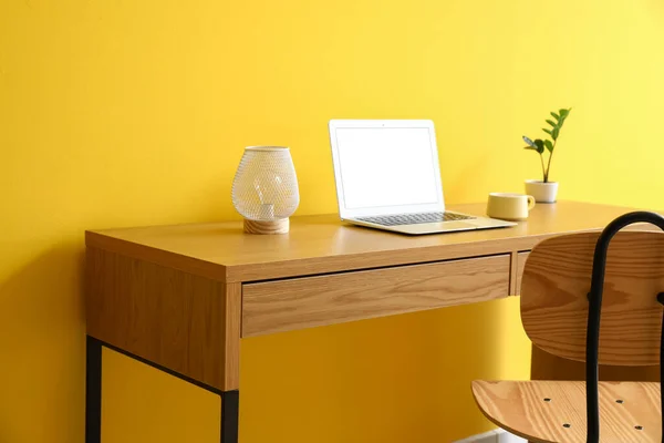 Träbord Med Modern Laptop Lampa Kopp Och Krukväxt Nära Gul — Stockfoto