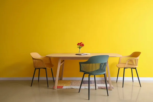 Τραπέζι Φαγητού Λουλούδια Και Περιοδικό Κοντά Χρωματιστό Τοίχο — Φωτογραφία Αρχείου