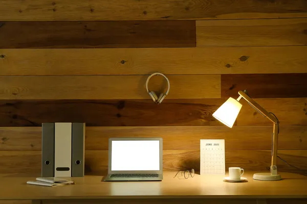 Современное Рабочее Место Открытым Ноутбуком Светящейся Лампой Возле Деревянной Стены — стоковое фото