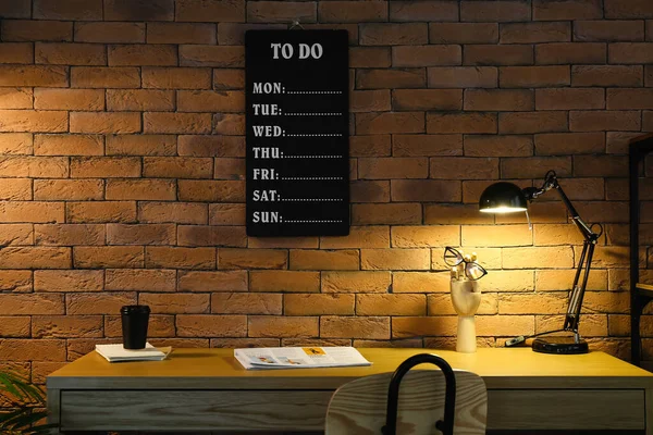 Modern Workplace Glowing Lamp Cup Coffee Brick Wall — Stock Photo, Image