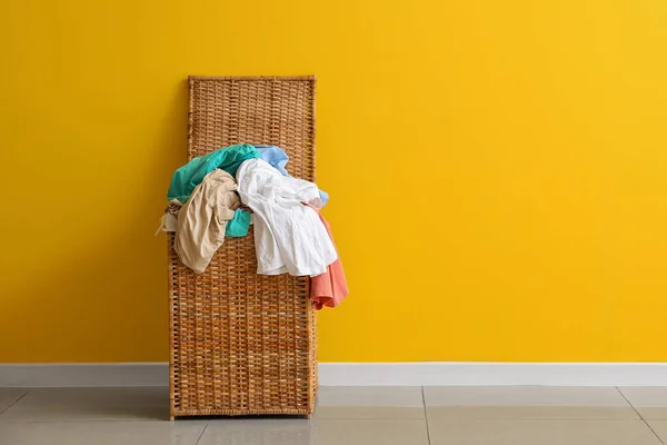 Sarı Duvarın Yanında Kirli Giysilerle Dolu Bir Sepet — Stok fotoğraf