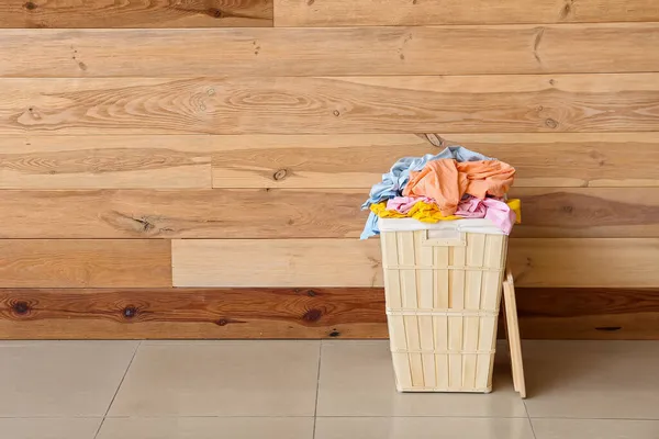 Ahşap Duvarın Yanında Kirli Çamaşırlarla Dolu Bir Sepet — Stok fotoğraf