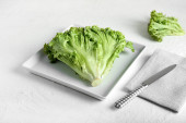 Talíř s čerstvým salátem a nožem na světlém pozadí