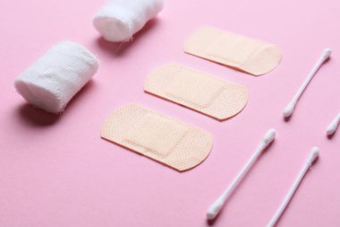 Renkli arka planda bandaj, tıbbi sıvalar ve pamuk tomurcukları, yakın plan