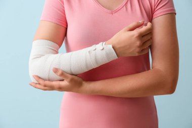 Renkli arka planda elleri bandajlı genç kadın.