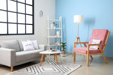 Modern odanın içinde şık bir koltuk ve pencere ve renk duvarı olan bir kanepe.