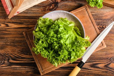 Ahşap arka planda taze marul kasesi.