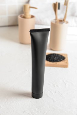 Banyodaki masada aktif karbon içeren siyah diş macunu.