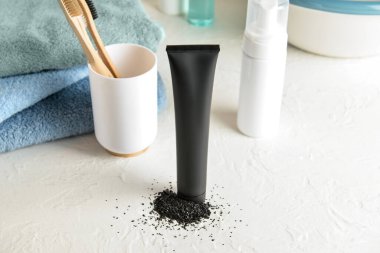 Banyodaki masada aktif karbon içeren siyah diş macunu.