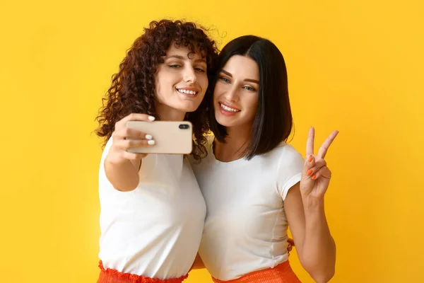 Young Sisters Showing Victory Gesture Taking Selfie Color Background — Stock Photo, Image