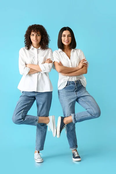 Young Sisters Crossed Hands Standing Color Background — Stock Photo, Image