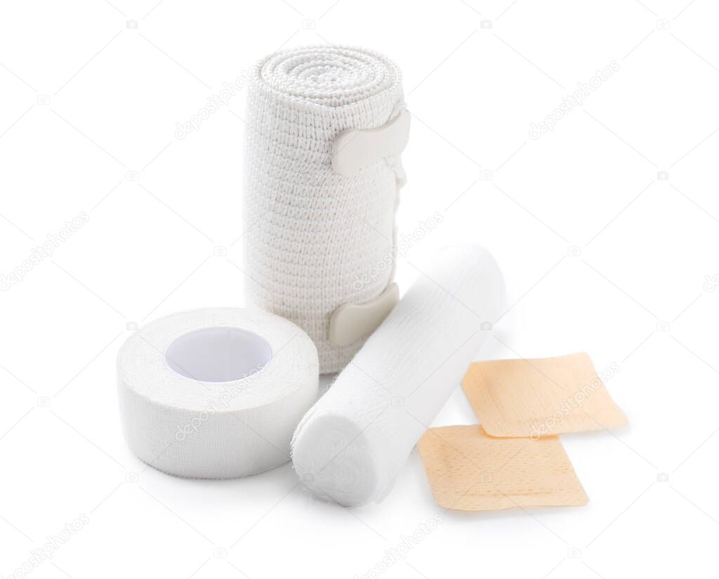 Medical plasters, gauze rolls and elastic bandage on white background