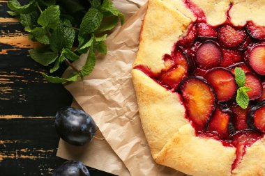 Lezzetli erik galeti ve koyu ahşap arka planda naneli parşömen, yakın plan.