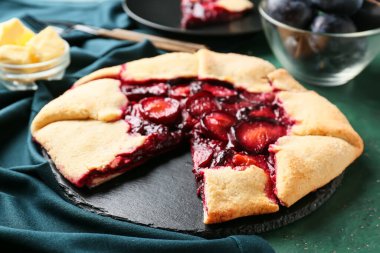 Renk arkaplanında lezzetli erik galeti olan tahta tabak, yakın plan.