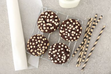 Gri arka planda beyaz çikolata parçalı lezzetli kurabiyeler.