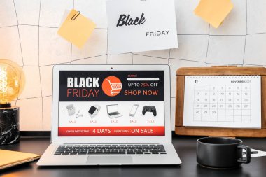 Bilgisayarında çevrimiçi mağaza ve takvim sayfası açık. Kara Cuma