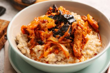 Lezzetli yulaf ezmeli kase, biftek ve kuru erikli sos, yakın plan.