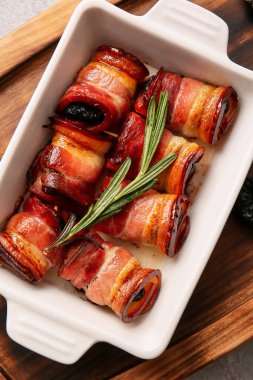 Gevrek pastırma ve ahşap tahtada biberiye dalında pişirilmiş lezzetli kuru erikli fırın.