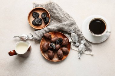 Kuru erikli çikolata şekerlemeleri, arka planda bir fincan kahve ve süt.