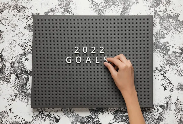 Kvinna Hand Med Text 2022 Goals Ombord Mot Grunge Bakgrund — Stockfoto