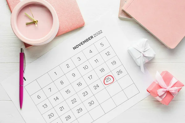 白木の背景に黒金曜日 贈り物や目覚まし時計のマーク日付カレンダーページ — ストック写真