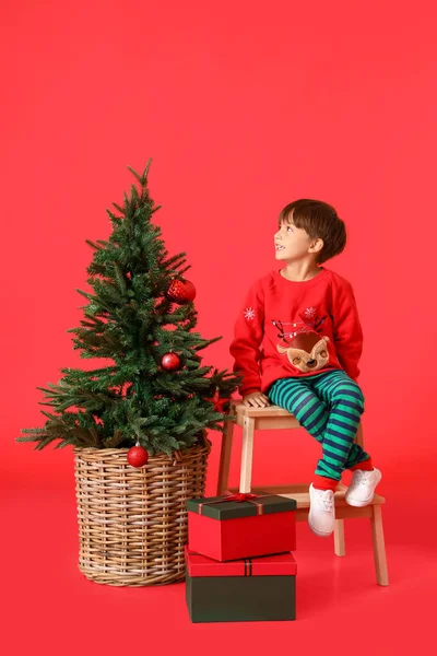身穿圣诞服装 红底冷杉树的小男孩 — 图库照片
