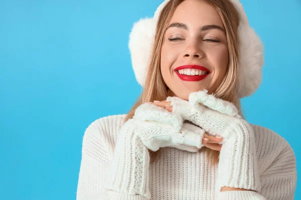 美しいです若いです女性でEarmuff上の青背景 — ストック写真