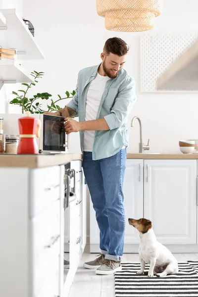 Young Man Cute Dog Adjusting Microwave Oven Kitchen — Stock Photo, Image