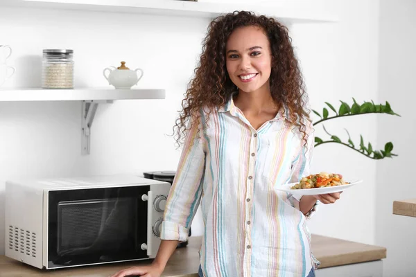 Young African American Woman Holding Plate Food Microwave Oven Kitchen — Stock Photo, Image