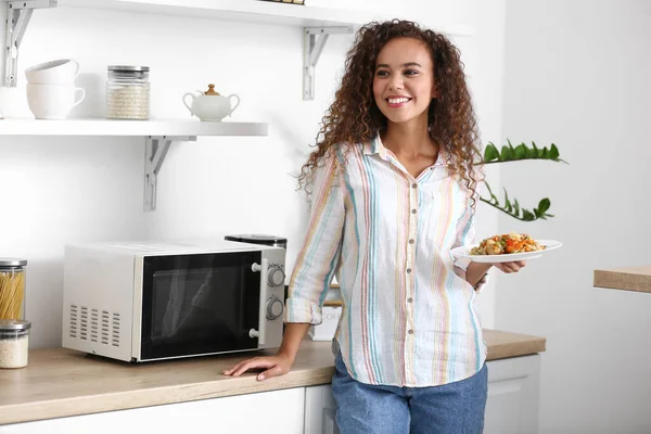 Young African American Woman Holding Plate Food Microwave Oven Kitchen — Stock Photo, Image