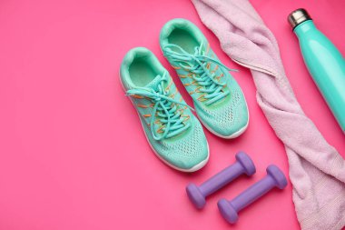 Dambıllar, havlu ve pembe arka planda ayakkabılar.