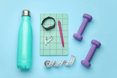 Dambıllar, aletler, mezura ve mavi arka planda bir şişe su.