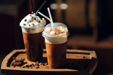 Odada kremalı plastik bardakta buzlu kahve.