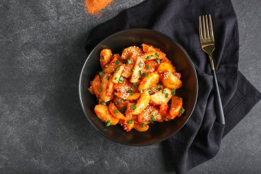 Koyu arkaplanda bal biberli patates tabağı.