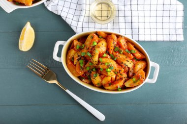 Bal biberli fırın tabağı ahşap arka planda kırmızı patates.