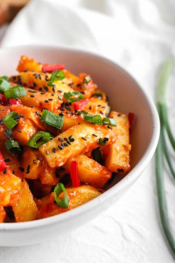 Hafif arka planda bal biberli patates kasesi.