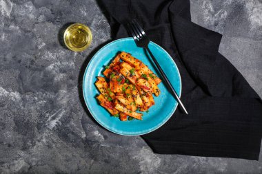 Arkaplanda bal biberli patates tabağı.