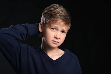 Siyah arka planda üzgün küçük bir çocuğun portresi