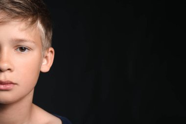 Siyah arka planda küçük bir çocuğun portresi, yakın plan.