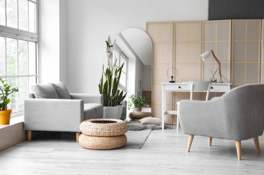 Modern oturma odasının içinde şık bir ayna, koltuk ve koltuk var.