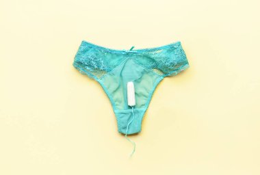 Sarı arka planda regl tamponu ve külot.