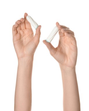 Beyaz arka planda adet tamponu olan kadın elleri.