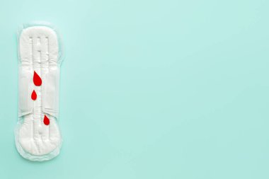 Mavi arka planda regl pedi ve kağıt kan damlaları