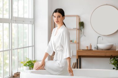 Güzel genç bayan evde banyo yapmaya hazırlanıyor.