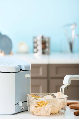 Mutfakta patates kızartması ve kızartma makinesi olan sepet.